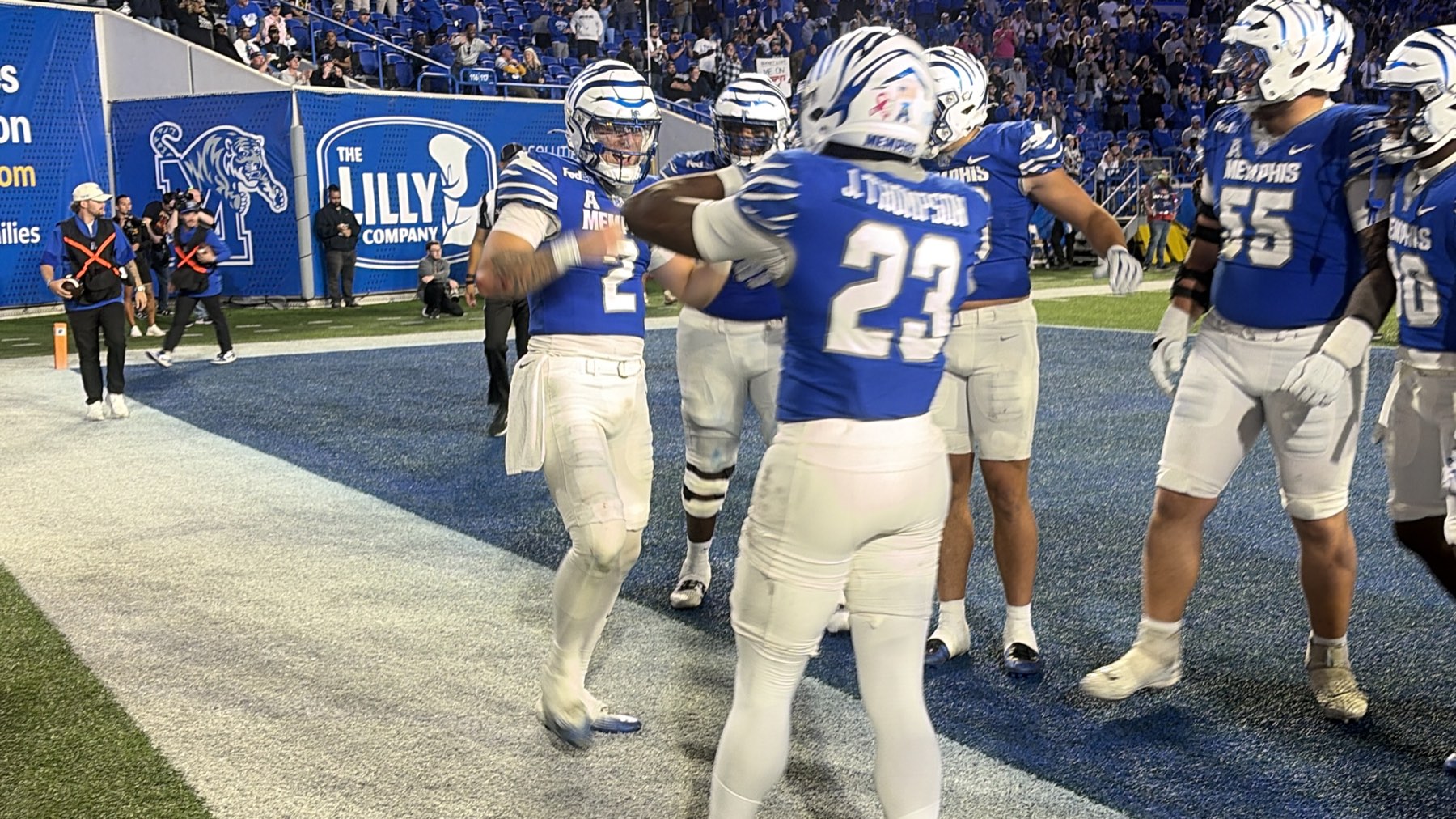 Memphis players celebrating together in the end zone at Simmons Bank Liberty Stadium